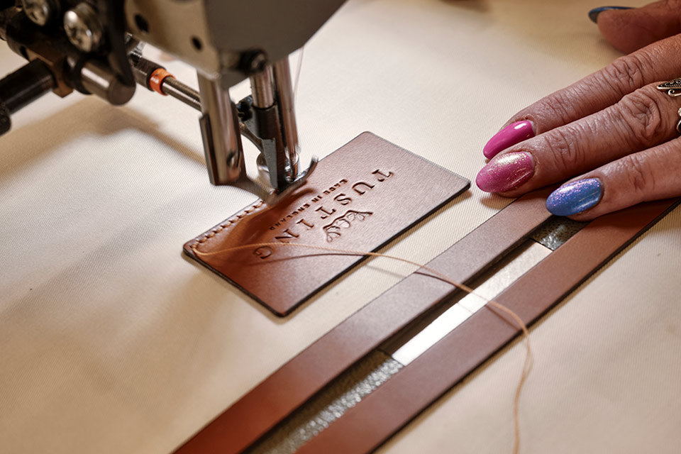 The Tusting Logo being sewn into a bag